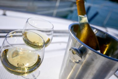 Çift kadehlerin ve kova yatında şampanya şişesi ile