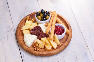 peynir Beyaz ahşap arka planda, zeytinli plaka yakın çekim  