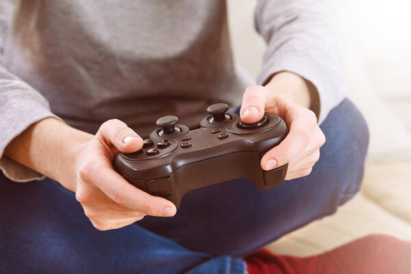 man holding joystick controllers while playing video games at home