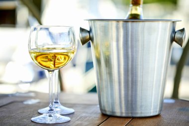 Çift kadehlerin ve kova ile yatta beyaz şarap şişesi