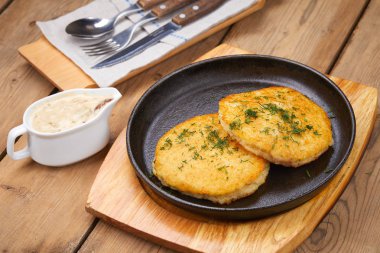 plaka soslu, ahşap kesme tahtası üzerinde patates pancakes ile yakın çekim 