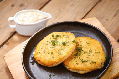 plaka soslu, ahşap kesme tahtası üzerinde patates pancakes ile yakın çekim 