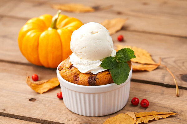 pumpkin cake with ice cream in white bowl, close-up 