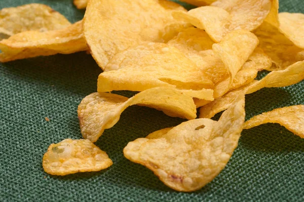 potato chips on green background, close-up