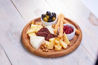 peynir Beyaz ahşap arka planda, zeytinli plaka yakın çekim  