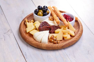 peynir Beyaz ahşap arka planda, zeytinli plaka yakın çekim  