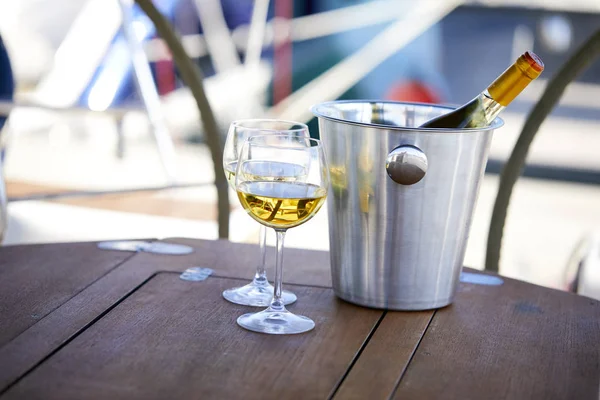 Çift kadehlerin ve kova ile yatta beyaz şarap şişesi