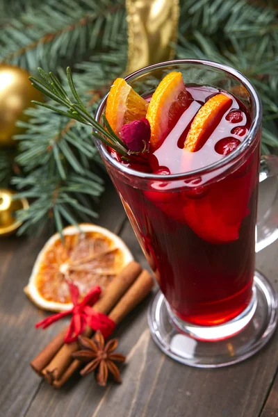 mulled wine with orange and cinnamon on wooden background, close-up