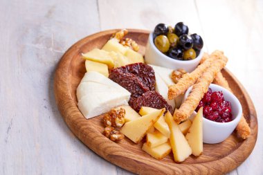 peynir Beyaz ahşap arka planda, zeytinli plaka yakın çekim  