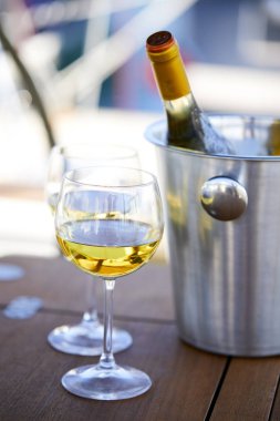 Çift kadehlerin ve kova ile yatta beyaz şarap şişesi