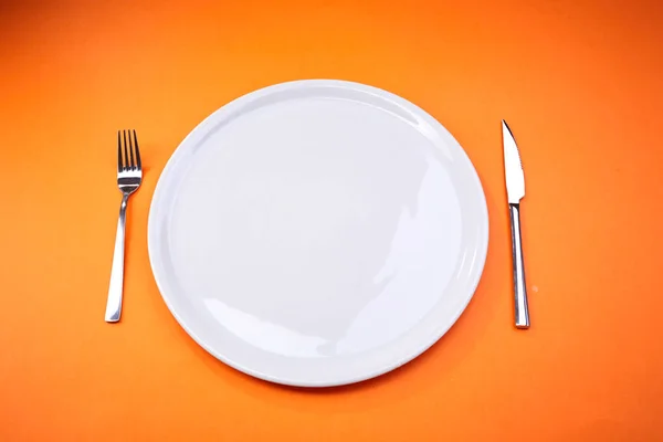 Пустая Тарелка Вилкой Ножом Оранжевом Фоне — стоковое фото