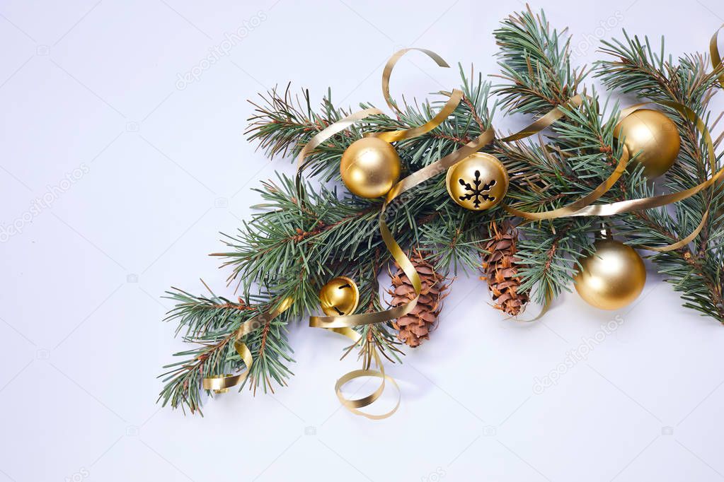 Christmas tree branch with golden balls and ribbons with pine cones