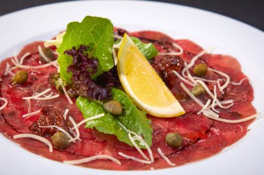 dana Carpaccio Kapari beyaz tabakta ile yakın çekim 