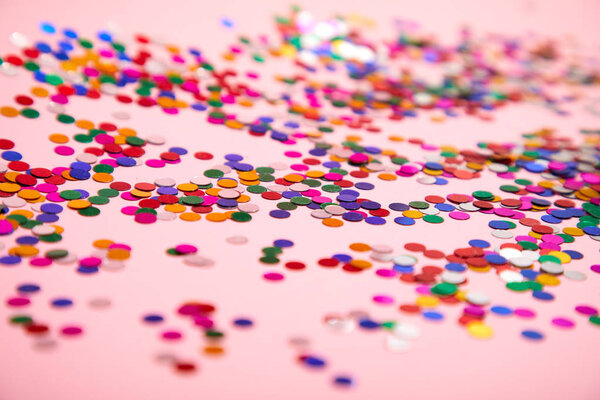 праздничные конфетти на розовом фоне, крупным планом
 
