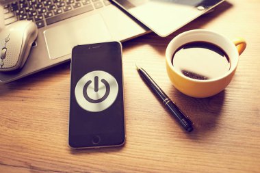  Modern akıllı telefonlu ofis masası ve ekranda düğme gücü, iş konsepti 