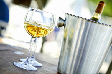 Çift kadehlerin ve kova ile yatta beyaz şarap şişesi