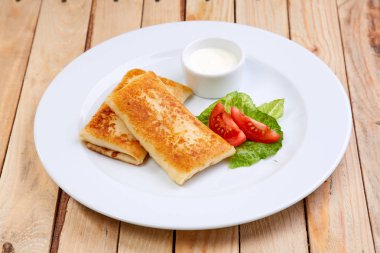 Beyaz tabakta krep ekşi krema ile doldurulmuş yakın çekim 