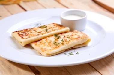 Beyaz tabakta krep ekşi krema ile doldurulmuş yakın çekim 