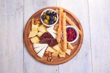 peynir Beyaz ahşap arka planda, zeytinli plaka yakın çekim  