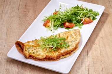 omlet beyaz tabakta salata ile yakın çekim 