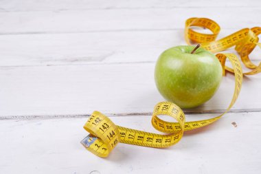ahşap masa, yakın çekim, diyet kavramı kasette ölçme ile elma  