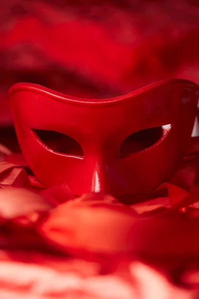carnival red mask for holiday with ribbons on dark background