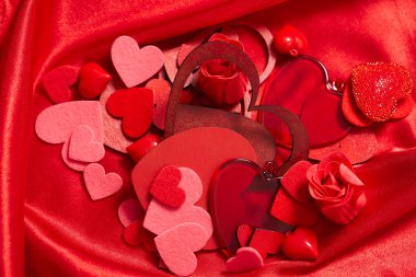 Sevgililer günü süsleri kırmızı ipek kumaş üzerine yürekleri 
