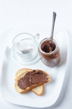 krem çikolata ve cam kavanoz tepsi, tatlı kahvaltı konsepti ile çay poşeti ile ekmek