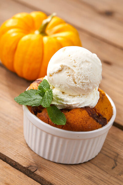 pumpkin cake with ice cream in white bowl, close-up 