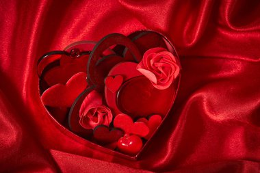 Sevgililer günü süsleri kırmızı ipek kumaş üzerine yürekleri 