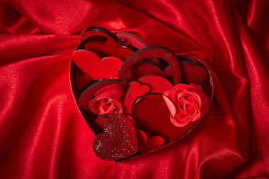 Sevgililer günü süsleri kırmızı ipek kumaş üzerine yürekleri 