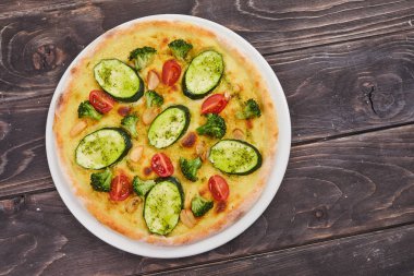 vejetaryen pizza ahşap arka plan üzerinde beyaz plaka