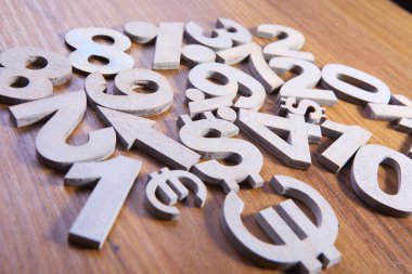 Sayı ve para birimi simgelerini ahşap arka plan üzerinde kümesi yakın çekim 