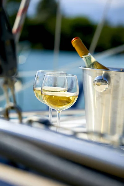 Pair of wineglasses and bucket with wine bottle on yacht