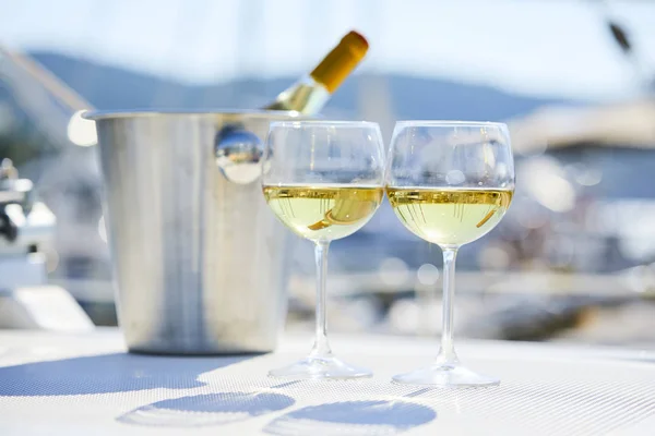 Pair of wineglasses and bucket with wine bottle on yacht