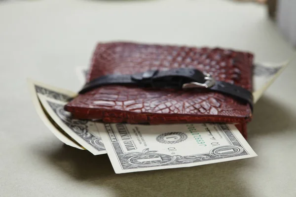 wallet with money wrapped with belt, close-up