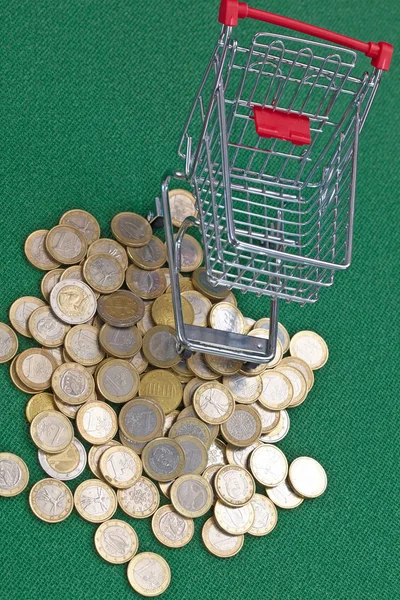 在绿色背景购物篮下的欧元硬币 — 图库照片