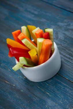 ahşap masa üzerinde beyaz kase taze sebze dilim 