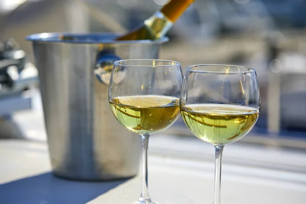 Pair of wineglasses and bucket with wine bottle on yacht