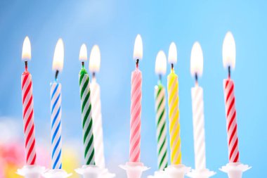 mavi arka plan üzerinde renkli doğum günü mumları