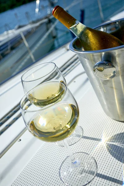Pair of wineglasses and bucket with wine bottle on yacht