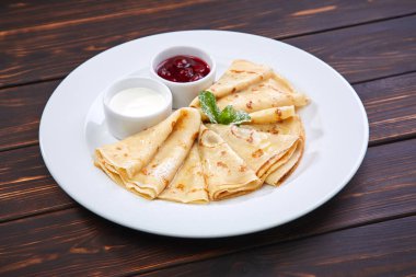 Krep ekşi krema ve beyaz tabakta berry sos ile yakın çekim 