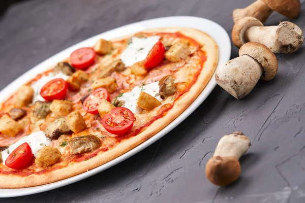 pizza with mushrooms on white plate, close-up