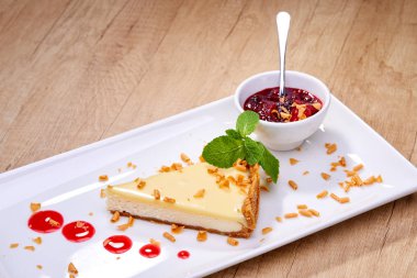 Beyaz tabakta berry soslu cheesecake yakın çekim 