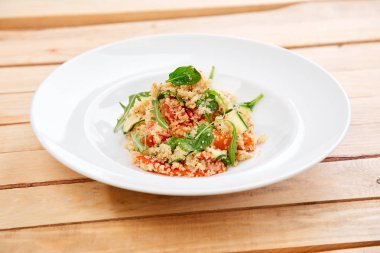 İsrail kuskus ve beyaz tabakta doğranmış yaz sebze, yakın çekim içeren Akdeniz yetenek ile yaz salatası 