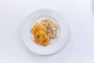 Beyaz plaka üzerinde arpa ile kızarmış tavuk göğsü, yakın çekim 