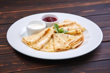 Krep ekşi krema ve beyaz tabakta berry sos ile yakın çekim 