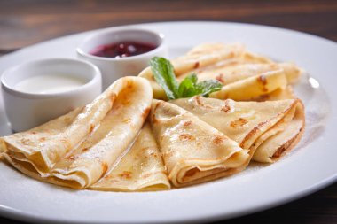 Krep ekşi krema ve beyaz tabakta berry sos ile yakın çekim 