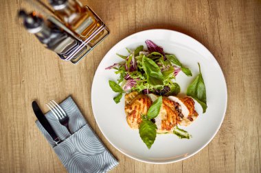 Beyaz plaka üzerinde ızgara tavuk göğsü ve salata, yakın çekim 