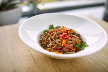 Beyaz plaka üzerinde sığır eti ve Chopsticks ile kızartma erişte soba, yakın çekim 